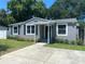 Charming single-story home with well-maintained landscaping, gray exterior, and a concrete driveway and carport at 2709 S Manhattan Ave, Tampa, FL 33629