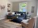 Inviting living room featuring a comfortable gray sectional sofa, stylish decor, and natural light from a large window at 2709 S Manhattan Ave, Tampa, FL 33629