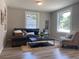 Inviting living room featuring a comfortable gray sectional sofa, stylish decor, and natural light from large windows at 2709 S Manhattan Ave, Tampa, FL 33629