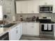 Bright kitchen featuring white cabinetry, marble-style countertops, and stainless steel appliances at 2714 60Th Avenue W Ter # 12D, Bradenton, FL 34207