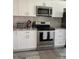 Elegant kitchen featuring white cabinets, stainless steel appliances, and stylish backsplash and flooring at 2714 60Th Avenue W Ter # 12D, Bradenton, FL 34207