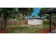 A storage shed sits within the backyard, alongside a wooden fence and plenty of shade from a mature tree at 323 48Th Nw St, Bradenton, FL 34209