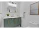 Stylish bathroom features a green vanity with gold hardware, a unique mirror, and modern fixtures at 323 48Th Nw St, Bradenton, FL 34209