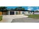 Well-maintained single-story home featuring a black roof and a spacious driveway leading to a garage at 323 48Th Nw St, Bradenton, FL 34209