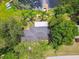 Overhead view of a house, emphasizing its lot features, mature trees, backyard firepit, and waterfront access at 3366 Clover Leaf Ln, Land O Lakes, FL 34639