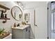 Bathroom features a modern vanity, round mirror and wood-look shelving at 3366 Clover Leaf Ln, Land O Lakes, FL 34639