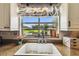 Kitchen sink with a view of the beautiful backyard and lake, complemented by a floral-themed window treatment at 3366 Clover Leaf Ln, Land O Lakes, FL 34639