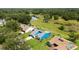 An aerial view reveals a home with manicured lawn near a pond, complemented by lush greenery and community walking trails at 34507 Cedarfield Dr, Dade City, FL 33523
