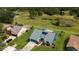 An aerial shot captures a home with a well-manicured lawn and a serene community setting by a tranquil pond at 34507 Cedarfield Dr, Dade City, FL 33523