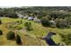 A picturesque aerial view features a blue house with pond and lush green space at 34507 Cedarfield Dr, Dade City, FL 33523