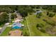 An aerial perspective showcases a well-maintained home with lush surroundings near a tranquil pond in a serene community at 34507 Cedarfield Dr, Dade City, FL 33523
