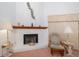 Inviting fireplace with whitewashed brick, wood mantel, and a traditional chair for relaxation at 34507 Cedarfield Dr, Dade City, FL 33523