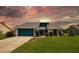 Charming single-Gathering home showcasing a well-maintained lawn, complemented by tasteful landscaping and a vibrant blue garage door at 34507 Cedarfield Dr, Dade City, FL 33523