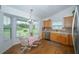 Bright kitchen nook with wood floors, large windows overlooking backyard, and wooden cabinets at 34507 Cedarfield Dr, Dade City, FL 33523
