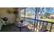 Relaxing balcony with a table and chairs offering a scenic view of the tranquil lake and lush greenery at 3505 Tarpon Woods Blvd # I407, Palm Harbor, FL 34685
