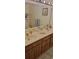 Bathroom featuring a double sink vanity with wooden cabinets and a large mirror at 3505 Tarpon Woods Blvd # I407, Palm Harbor, FL 34685