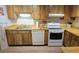 Well-lit kitchen with wood cabinets, laminate countertops and white appliances at 3505 Tarpon Woods Blvd # I407, Palm Harbor, FL 34685
