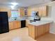 Bright kitchen featuring wood cabinets, laminate countertops, and black appliances at 403 E Carolina Ave, Plant City, FL 33563