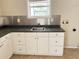 Bright laundry room featuring white cabinets, laminate countertops, and stainless steel backsplash at 403 E Carolina Ave, Plant City, FL 33563
