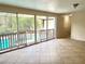 Living room featuring tile floors and sliding glass doors leading to the screened-in pool area at 403 E Carolina Ave, Plant City, FL 33563