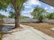 A large, fenced-in backyard features concrete areas and trees at 4215 E Paris St, Tampa, FL 33610