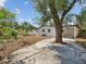 Spacious backyard with mature trees, a large concrete patio area, and partial fencing at 4215 E Paris St, Tampa, FL 33610