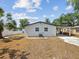 Rear exterior view of the home, featuring a covered patio and landscaped yard with mature trees at 4215 E Paris St, Tampa, FL 33610