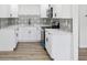 Bright kitchen features white cabinetry, modern appliances, and tile backsplash at 4215 E Paris St, Tampa, FL 33610
