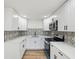 Modern kitchen featuring white cabinets, stainless steel appliances, attractive backsplash, and light countertops at 4215 E Paris St, Tampa, FL 33610