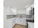 Updated kitchen features white cabinets, stainless steel appliances, and mosaic backsplash at 4215 E Paris St, Tampa, FL 33610