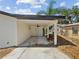 Covered patio with concrete flooring, white support columns, ceiling fan, and white door at 4215 E Paris St, Tampa, FL 33610