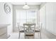 Cozy dining area with white table and chairs, complemented by natural light through window with blinds at 4655 Wallingford Ct # 4655, New Port Richey, FL 34655