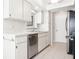 Bright kitchen featuring white cabinetry, stainless steel dishwasher, and neutral countertops and backsplash at 4655 Wallingford Ct # 4655, New Port Richey, FL 34655