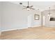 Spacious living room with light wood flooring, neutral walls, ceiling fan, and a view into other rooms at 4655 Wallingford Ct # 4655, New Port Richey, FL 34655