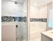 Bathroom featuring walk-in glass shower and bathtub with black and white tile accents at 4811 Haines N Rd, St Petersburg, FL 33714