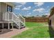Backyard featuring a wooden fence, grassy lawn, and a small porch at 4913 N Central Ave, Tampa, FL 33603