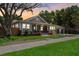Charming single Gathering home at dusk with inviting front porch and manicured lawn at 4913 N Central Ave, Tampa, FL 33603