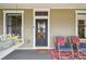 Close up of a charming front door with a wreath, rocking chairs, and a porch swing, offering a relaxing outdoor space at 4913 N Central Ave, Tampa, FL 33603