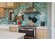 Close up of the cooktop with stainless steel vent hood and subway tile backsplash at 4913 N Central Ave, Tampa, FL 33603