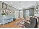 Bright living room with hardwood floors, piano, a patterned rug, and large windows providing natural light at 4913 N Central Ave, Tampa, FL 33603
