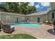 Private backyard pool surrounded by brick patio and lush landscaping at 4913 N Central Ave, Tampa, FL 33603