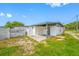 View of the home's backyard with healthy green lawn and a white-painted home with gray trim at 5109 Horton Rd, Plant City, FL 33567