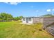 View of the home's backyard with healthy green lawn and a white-painted home at 5109 Horton Rd, Plant City, FL 33567