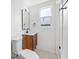 Bathroom with wooden vanity, white fixtures and marble-look tile floors at 5109 Horton Rd, Plant City, FL 33567