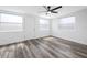 Bright bedroom with new gray wood flooring, ceiling fan, freshly painted walls, and natural light at 5109 Horton Rd, Plant City, FL 33567