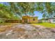 Exterior view of home featuring mature trees and a front porch, ready for renovation at 5109 Horton Rd, Plant City, FL 33567