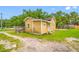 Side view of home showing siding, overgrown bushes, and a gravel driveway at 5109 Horton Rd, Plant City, FL 33567