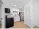 Modern kitchen features stainless steel refrigerator, black oven, and white cabinets at 5109 Horton Rd, Plant City, FL 33567