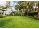 Manicured backyard features lush green grass, mature trees and landscaping at 5314 Alafia Falls Dr, Lithia, FL 33547
