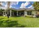 Spacious backyard with lush green grass, outdoor seating, and mature trees at 5314 Alafia Falls Dr, Lithia, FL 33547